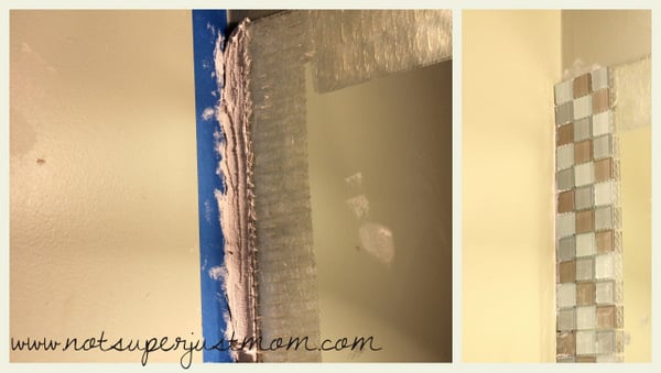 Pre-mixed adhesive and grout built up behind the tiles that overhang the edge of the mirror, supporting them against the wall